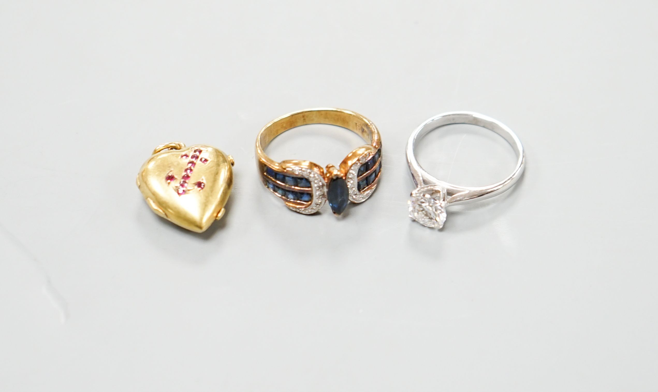 An 18ct gold and moissanite ring, size M/N, gross 3.4 grams, one other ring and a yellow metal and garnet set heart locket.